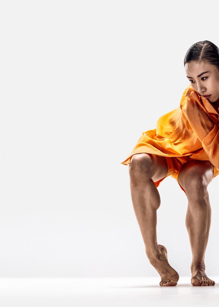 Jing Yi Wang, dansare på Skånes Dansteater i orange skjorta och shorts.