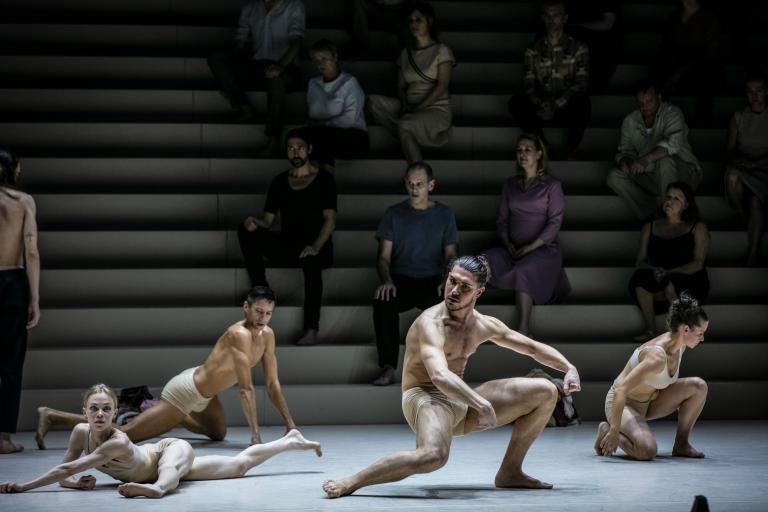 Dansare i hudfärgade underkläder dansar med armar och ben sträckta i olika vinklar.