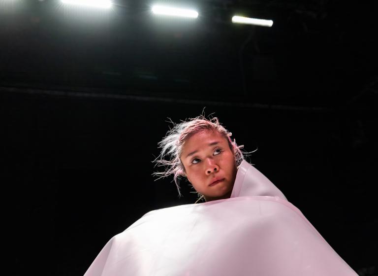 Dansaren Kat Nakui insvept i ett stort vitt plastgolv.