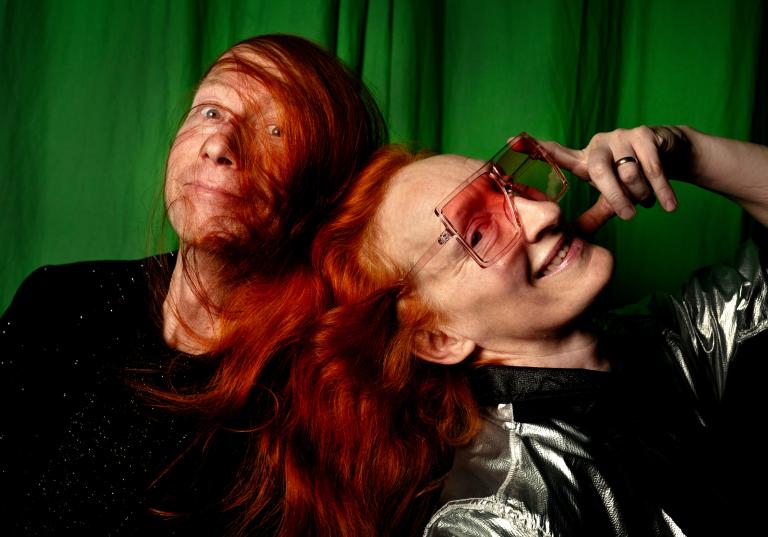 Koreografen Lidia Wos i silvrig jacka och rosatonade solglasögon lutar sig mot kompositören Anders Ortmans axel.